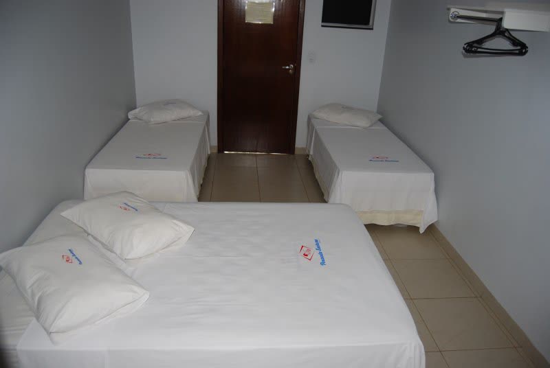 Quarto com cama de casal e camas de solteiro