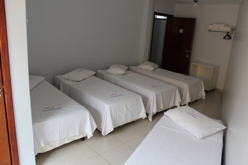 Quarto com várias camas e travesseiros brancos